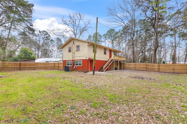 back of house with a lawn, stairway, a deck, cooling unit, and a fenced backyard