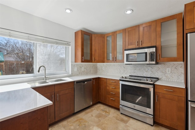 kitchen featuring appliances with stainless steel finishes, brown cabinetry, and a sink