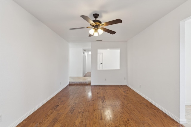 unfurnished room featuring visible vents, ceiling fan, baseboards, and hardwood / wood-style flooring