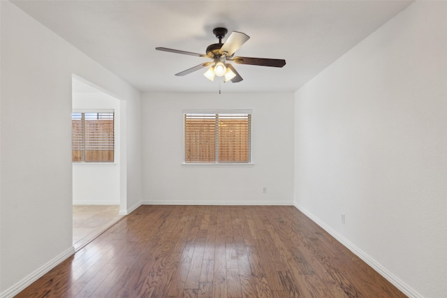 unfurnished room with ceiling fan, wood-type flooring, and baseboards