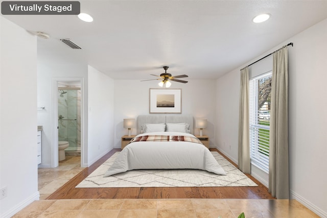 bedroom featuring baseboards, visible vents, ensuite bath, wood finished floors, and access to outside