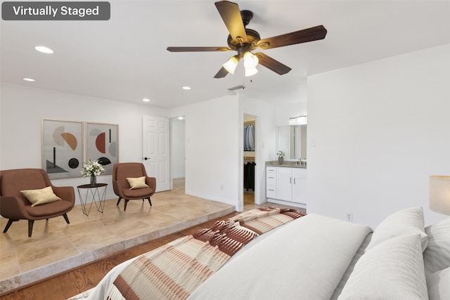 bedroom with light wood finished floors, a ceiling fan, a walk in closet, a closet, and recessed lighting