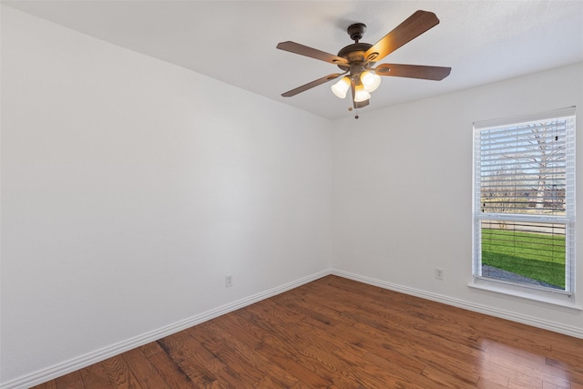 empty room featuring ceiling fan, baseboards, and wood finished floors