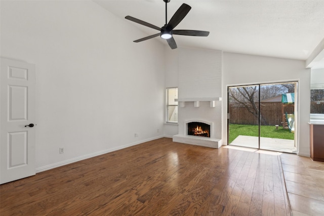 unfurnished living room with a healthy amount of sunlight, a fireplace, baseboards, and hardwood / wood-style flooring