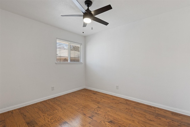 empty room with ceiling fan, baseboards, and wood finished floors