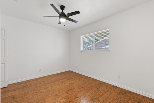 empty room with ceiling fan, wood finished floors, and baseboards