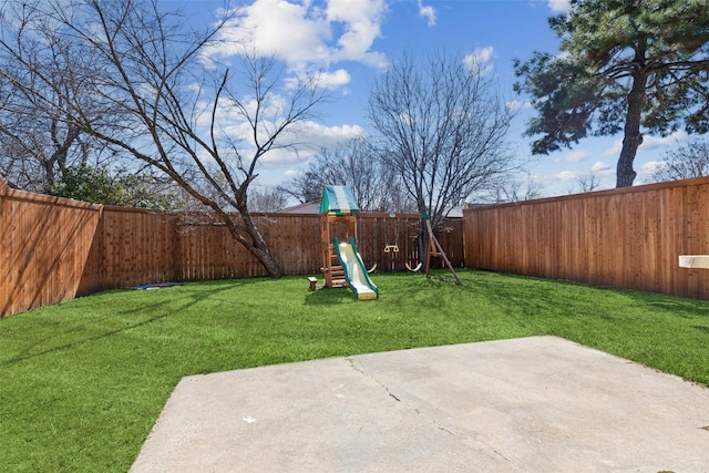 view of yard with a patio area, a playground, and a fenced backyard