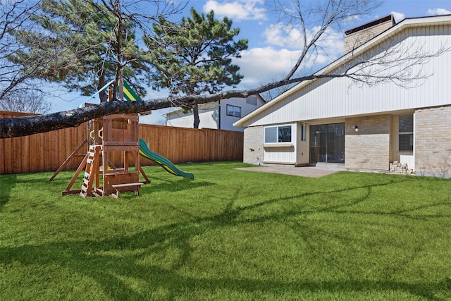 view of yard featuring a patio area, a playground, and a fenced backyard