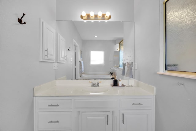 bathroom featuring a garden tub and vanity