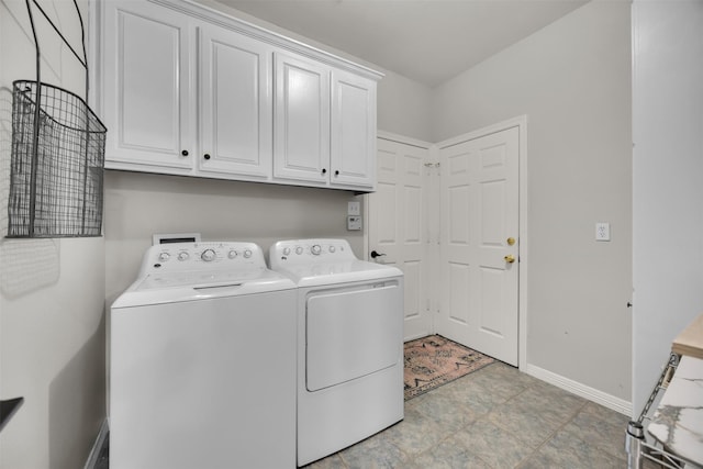 laundry room with washing machine and dryer, cabinet space, and baseboards