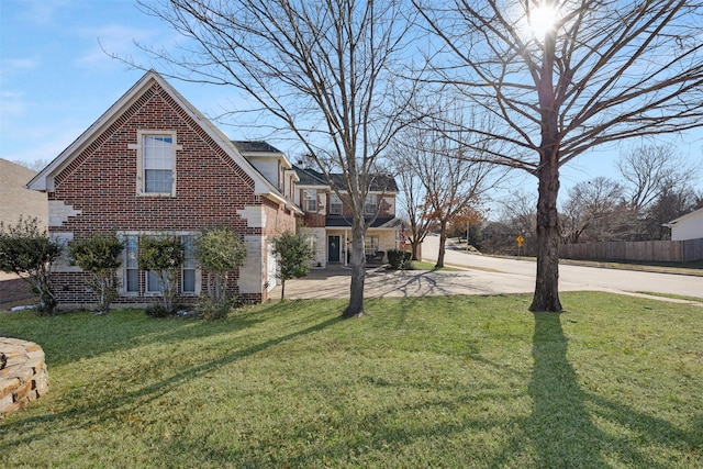 exterior space with a yard, brick siding, and fence