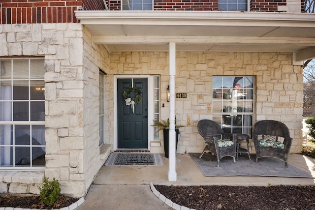 view of exterior entry with stone siding and brick siding