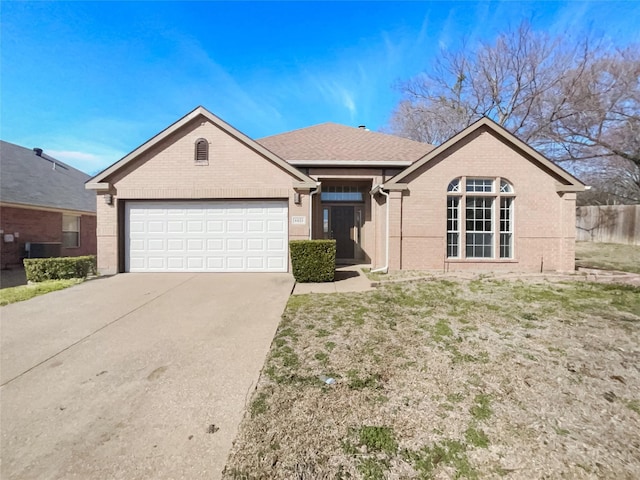 ranch-style house featuring an attached garage, brick siding, fence, concrete driveway, and roof with shingles