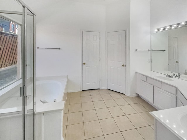 bathroom featuring tile patterned floors, a bath, and vanity