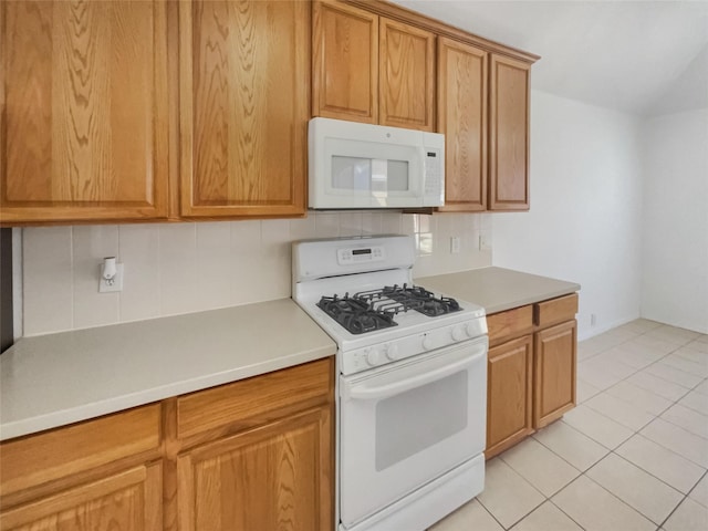 kitchen with white appliances, light tile patterned floors, decorative backsplash, brown cabinets, and light countertops