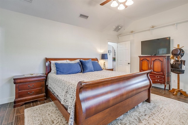 bedroom featuring lofted ceiling, wood tiled floor, visible vents, and baseboards