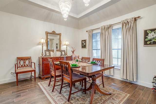 dining room featuring an inviting chandelier, baseboards, and wood finish floors