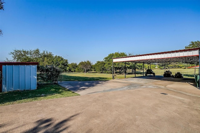 view of vehicle parking featuring a detached carport and concrete driveway