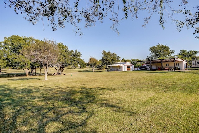 view of yard with a carport and an outbuilding