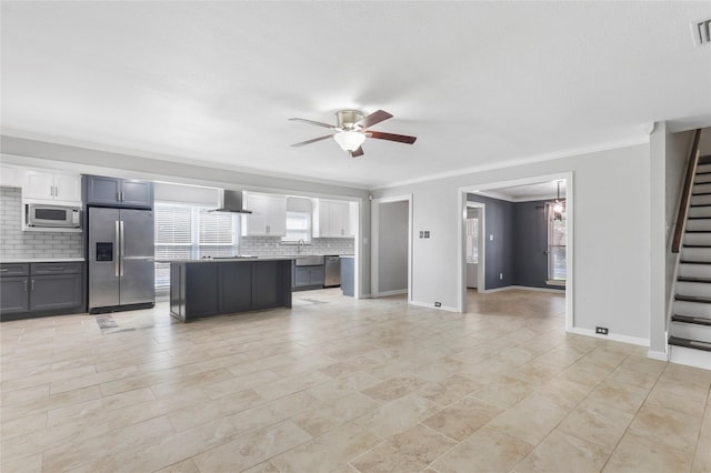 kitchen with visible vents, a ceiling fan, appliances with stainless steel finishes, wall chimney exhaust hood, and tasteful backsplash