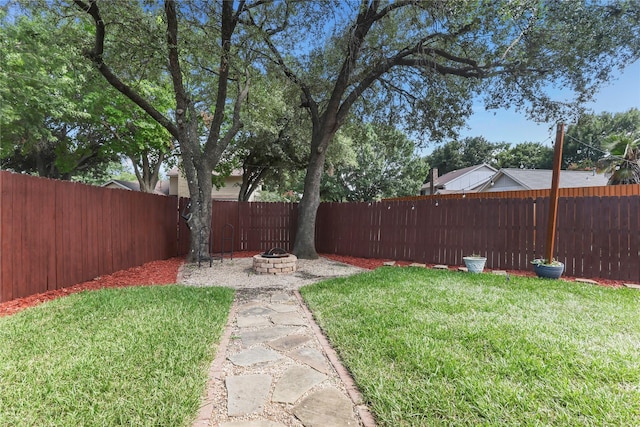 view of yard featuring an outdoor fire pit and a fenced backyard