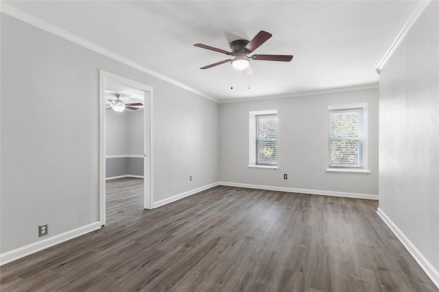 empty room featuring dark wood-style floors, ornamental molding, and baseboards