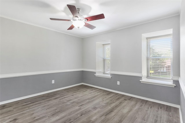 spare room featuring ceiling fan, baseboards, wood finished floors, and ornamental molding