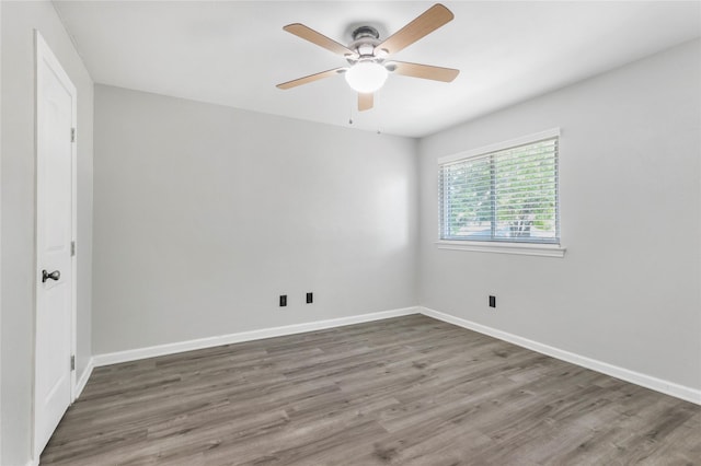 spare room featuring wood finished floors and baseboards