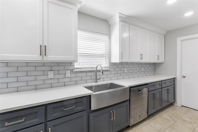 kitchen with light countertops, white cabinetry, a sink, and stainless steel dishwasher