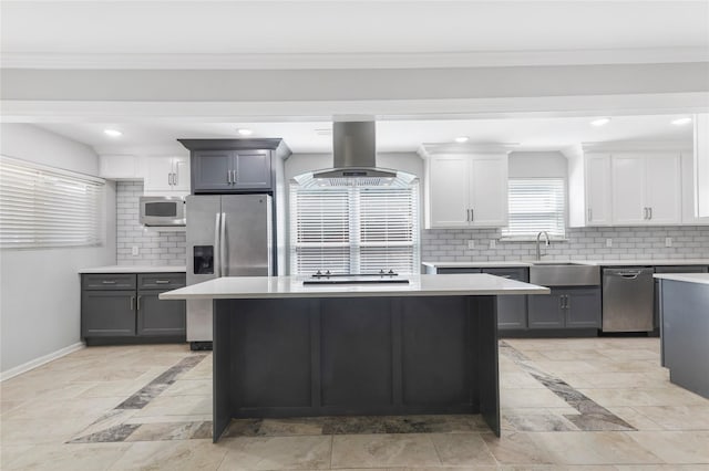 kitchen featuring a sink, light countertops, appliances with stainless steel finishes, a center island, and island exhaust hood