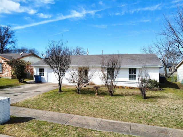 ranch-style home featuring roof with shingles, central air condition unit, concrete driveway, an attached garage, and a front yard