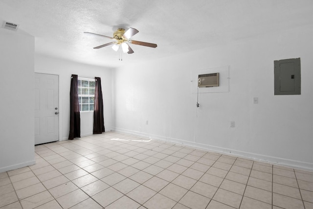 spare room featuring electric panel, visible vents, a ceiling fan, a wall mounted air conditioner, and a textured ceiling