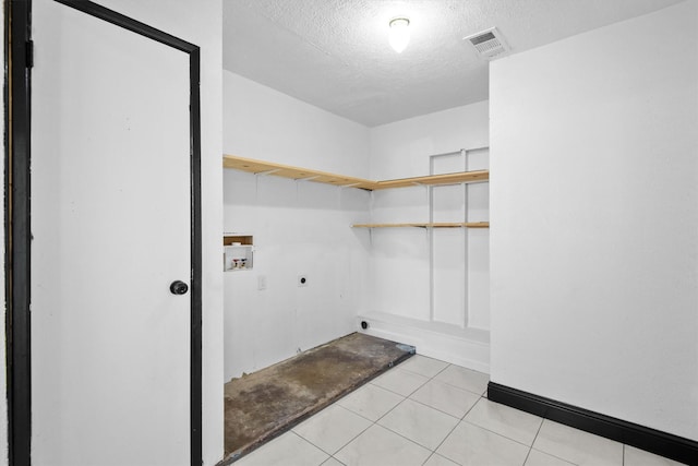 washroom featuring a textured ceiling, hookup for an electric dryer, laundry area, washer hookup, and visible vents