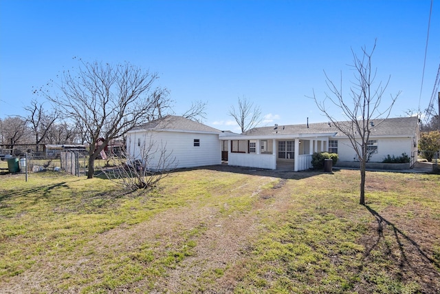 view of front facade featuring a front lawn, fence, and a sunroom