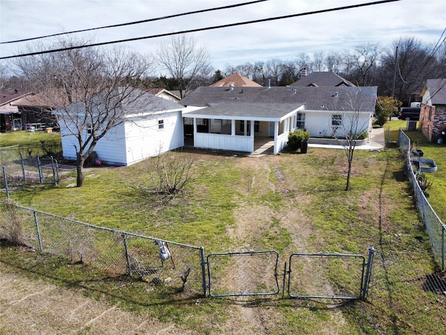 single story home with a sunroom, a fenced backyard, a gate, and a front yard