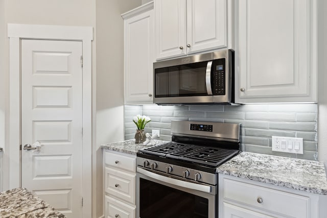 3830 Dalea Dr, Prosper, TX 75078 - kitchen featuring stainless steel appliances, white cabinets, decorative backsplash, and light stone countertops