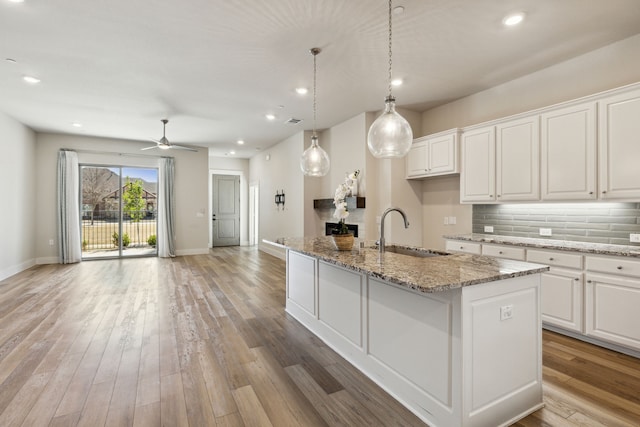 3830 Dalea Dr, Prosper, TX 75078 - kitchen featuring tasteful backsplash, light wood-style floors, open floor plan, white cabinetry, and a sink