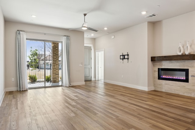 3830 Dalea Dr, Prosper, TX 75078 - unfurnished living room featuring baseboards, visible vents, a ceiling fan, light wood-style floors, and a fireplace