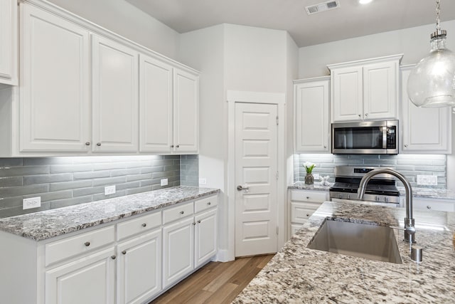 3830 Dalea Dr, Prosper, TX 75078 - kitchen with a sink, visible vents, white cabinetry, appliances with stainless steel finishes, and light stone countertops