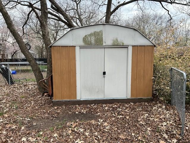 view of shed featuring fence