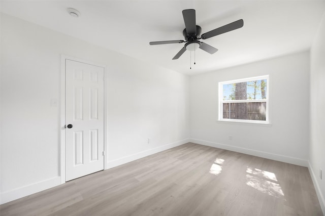 unfurnished room with light wood-type flooring, baseboards, and a ceiling fan