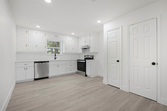 kitchen with light wood finished floors, stainless steel appliances, light countertops, white cabinetry, and a sink