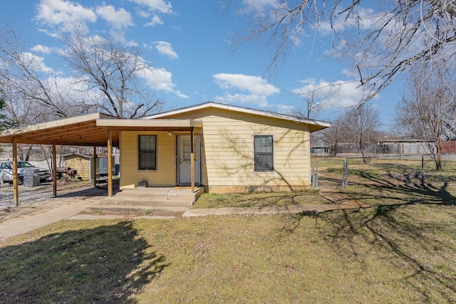 exterior space with a yard, a gate, fence, a carport, and driveway