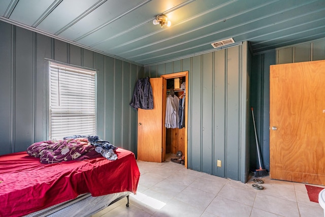 tiled bedroom featuring visible vents and a closet