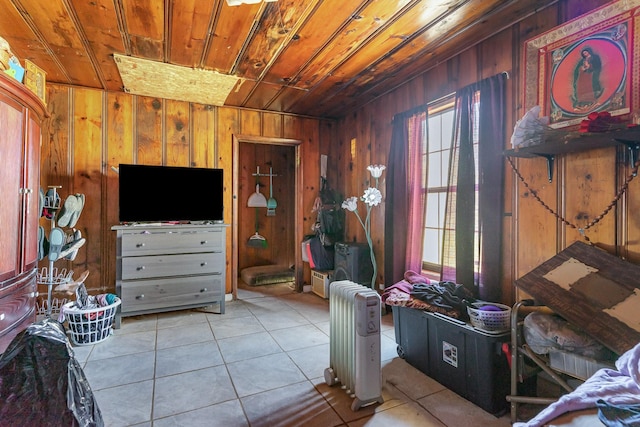 interior space featuring radiator, wooden ceiling, light tile patterned flooring, and wood walls