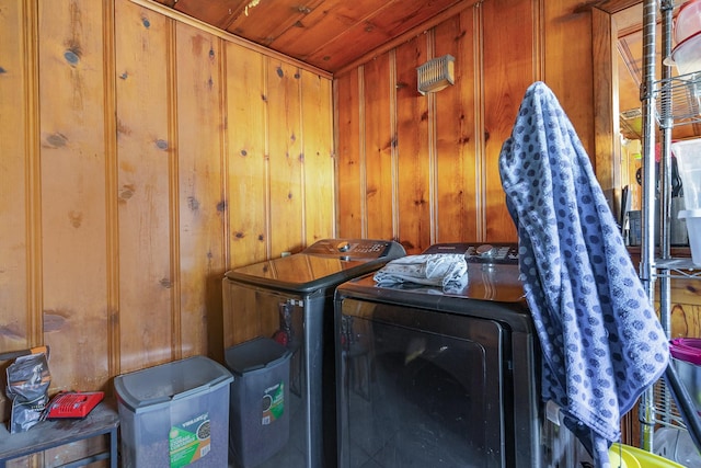 laundry room featuring laundry area, wooden walls, and washing machine and clothes dryer