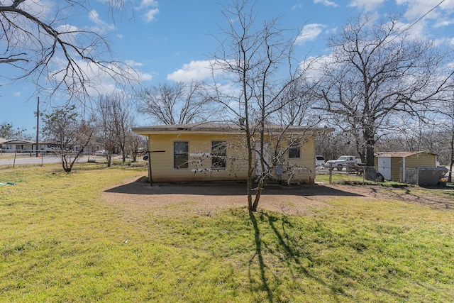 rear view of property with fence and a yard