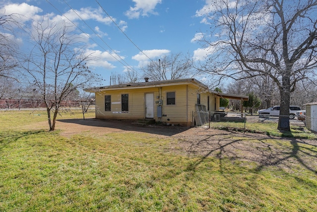 view of front of property featuring fence, an attached carport, and a front yard