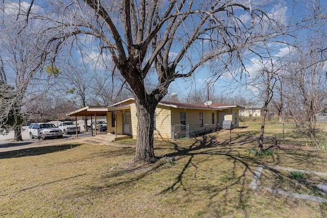 view of home's exterior featuring fence, an attached carport, and a lawn