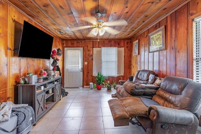 living room with light tile patterned floors, wood ceiling, ceiling fan, and wood walls